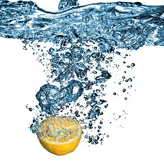 Image showing Fresh lemon dropped into water with bubbles isolated on white