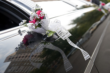 Image showing Door of black wedding car with flower and ribbon