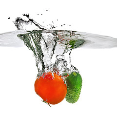 Image showing tomato and cucumber dropped into water isolated on white