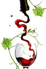 Image showing Pouring red wine in glass with rod isolated on white