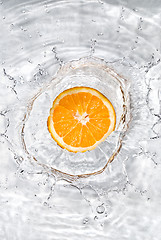 Image showing Fresh orange dropped into water with bubbles isolated on white