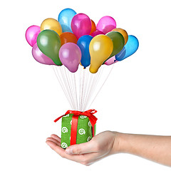 Image showing Hand holding gift with color balloons isolated on white