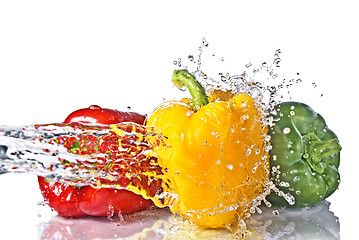 Image showing red, yellow and green pepper with water splash isolated on white