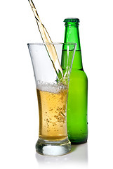 Image showing Beer pouring from into glass isolated with bottle on white