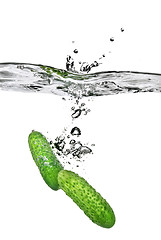 Image showing green cucumber dropped into water isolated on white