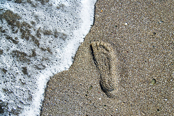 Image showing sand stones with footprint and water wave