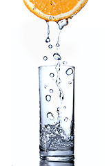 Image showing water drops in glass on orange isolated on white