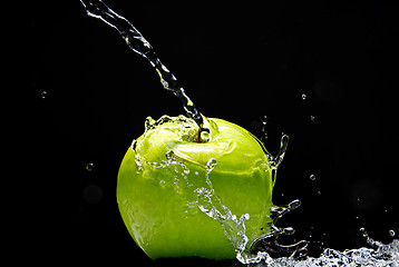 Image showing Green apple with water splash on black background