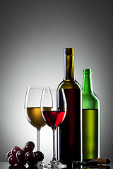 Image showing Red and white wine in glasses with grape and bottles