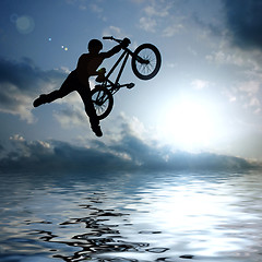 Image showing silhouette of boy with bicycle jumping in air