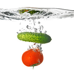 Image showing tomato and cucumber dropped into water isolated on white