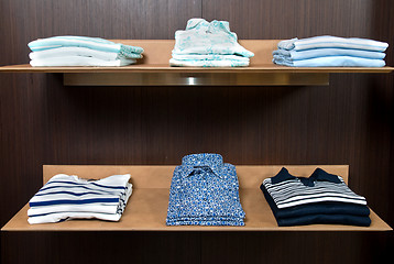 Image showing wooden store shelf with color clothes