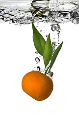 Image showing tangerine dropped into water with bubbles on white