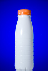 Image showing White milk bottle isolated on blue