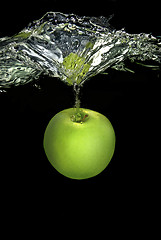 Image showing green apple dropped into water with splash isolated on black