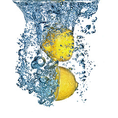 Image showing Fresh lemon dropped into water with bubbles isolated on white