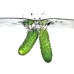 Image showing two green cucumbers dropped into water isolated on white
