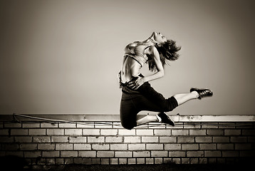 Image showing black and white photo of girl jumping on the roof