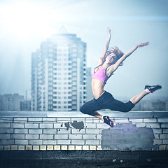 Image showing girl posing on the roof against city background
