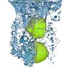 Image showing Fresh lime dropped into water with bubbles isolated on white