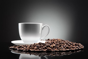 Image showing white cup with coffee beans on black