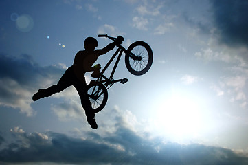 Image showing silhouette of boy with bicycle jumping in air