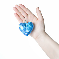 Image showing arm holding blue christmas ball in shape of heart isolated on wh