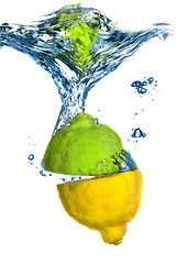 Image showing lemon and lime dropped into water with bubbles isolated on white