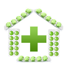 Image showing House from packs of green tablets and cross isolated on white