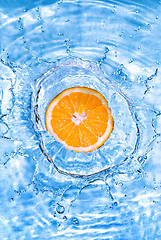 Image showing Fresh orange dropped into water with bubbles isolated on white