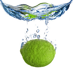 Image showing Fresh lime dropped into water with bubbles isolated on white