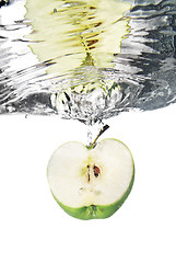 Image showing green apple dropped into water with bubbles isolated on white