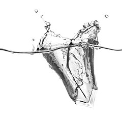 Image showing ice cube dropped into water with splash isolated on white