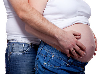 Image showing Man and woman's hands over pregnant belly on white