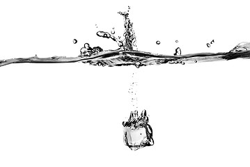 Image showing ice cube dropped into water with splash isolated on white