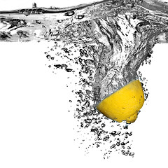 Image showing Fresh lemon dropped into water with bubbles isolated on white