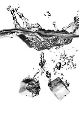 Image showing ice cubes dropped into water with splash isolated on white