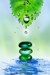 Image showing balancing spa shiny stones in water splash with leaf and drops