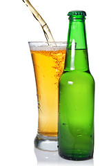 Image showing Beer pouring from into glass isolated with bottle on white