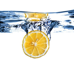 Image showing Fresh lemon dropped into water with bubbles isolated on white