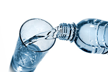 Image showing water pouring into glass from bottle isolated on white