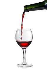 Image showing Pouring red wine in glass goblet isolated on white