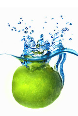 Image showing Fresh lime dropped into water with bubbles isolated on white