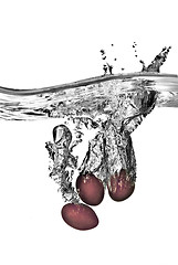 Image showing plum dropped into water with bubbles isolated on white