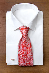 Image showing white shirt with red tie on wooden shelf