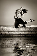 Image showing black and white photo of girl jumping on the roof in the water