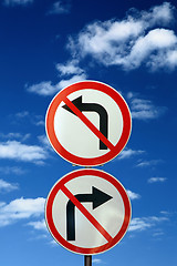 Image showing two opposite road signs against blue sky and clouds