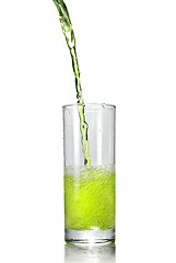 Image showing green juice pouring into glass isolated on white