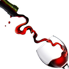 Image showing Pouring red wine in glass goblet isolated on white