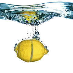 Image showing Fresh lemon dropped into water with bubbles isolated on white